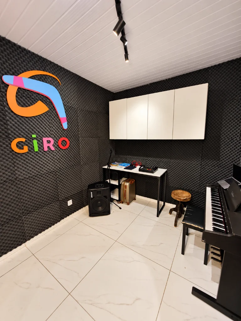 Estúdio musical com isolamento acústico, piano digital e logotipo da Escola Giro em Franca